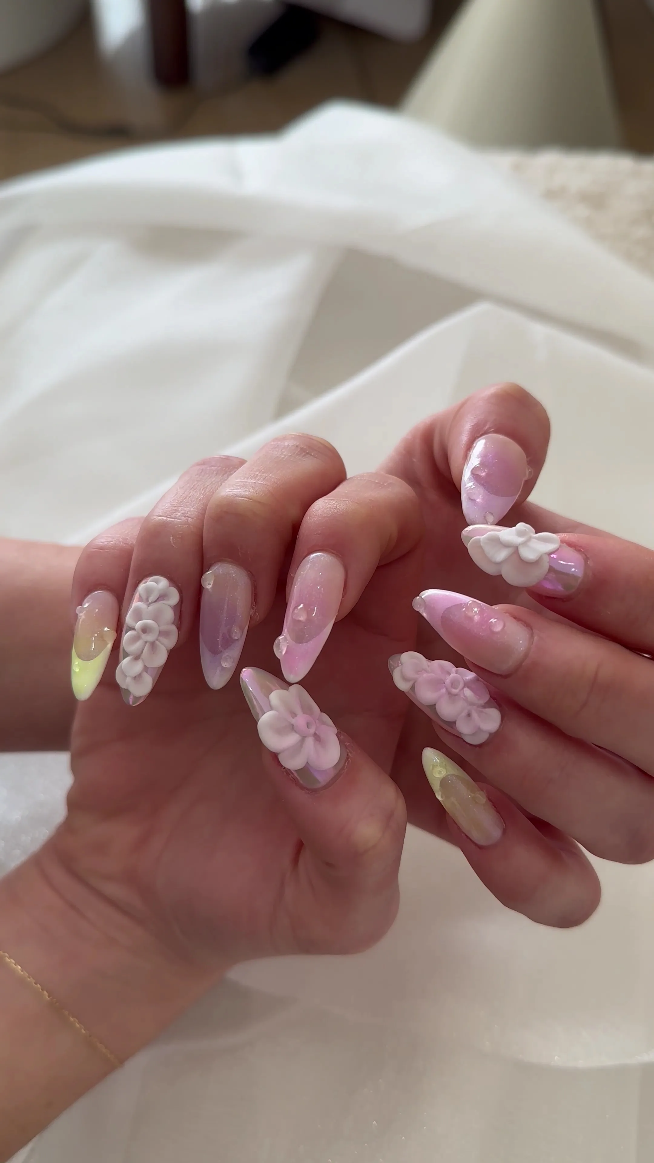 Long stiletto nails — iridescent finish with three-dimensional sculpted white and lilac gel flowers