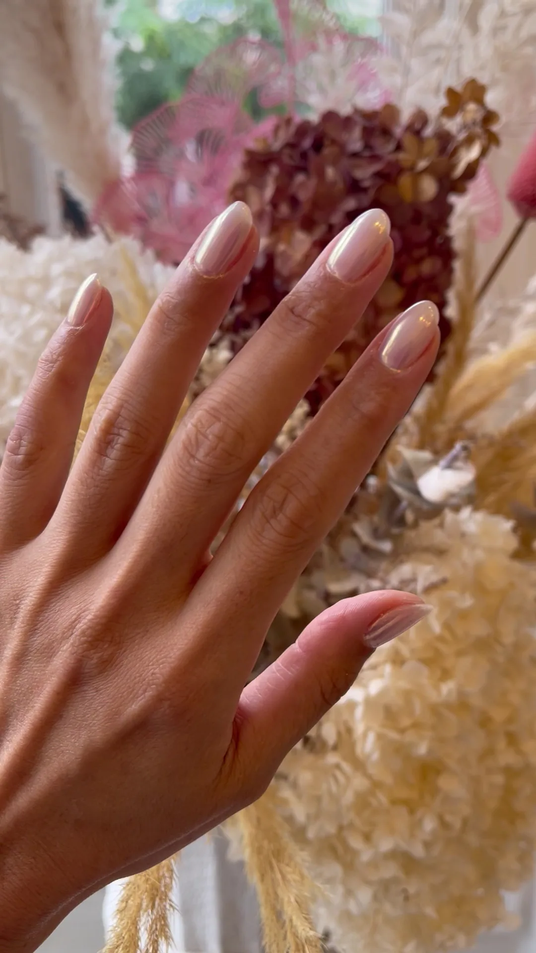 Chrome and pearl nude almond nails, hand photographed before dried pampas and hydrangea
